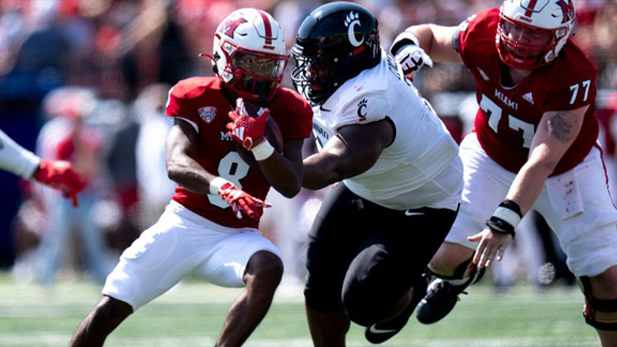 Miami Redhawks running back Kevin Davis (8) runs by Cincinnati Bearcats defensive tackle Dontay Corleone (2) in the first quarter of the College Football game at Yager Stadium in Cincinnati on Saturday, Sept. 14, 2024.