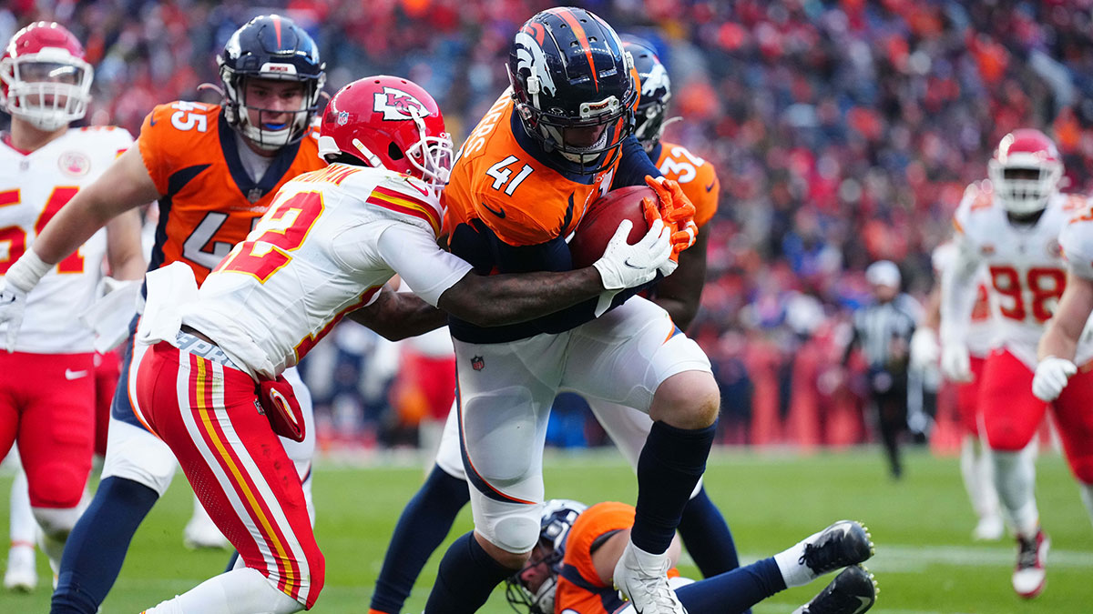 Denver Broncos linebacker Drew Sanders (41) advances a fumble recover as Kansas City Chiefs wide receiver Mecole Hardman Jr. (12) defends in the fourth quarter at Empower Field at Mile High.