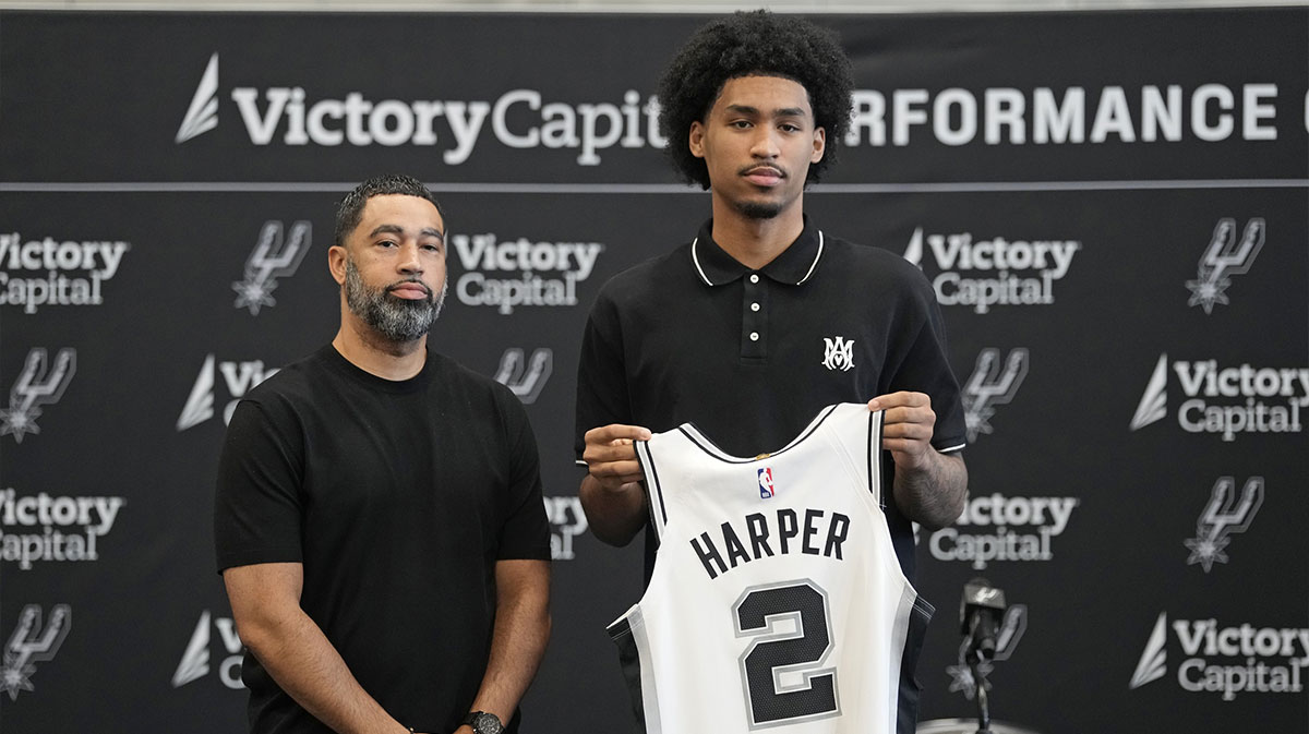 San Antonio first round draft pick Dylan Harper (2) holds up his jersey along with general manager Brian Wright at Victory Capital Performance Center.