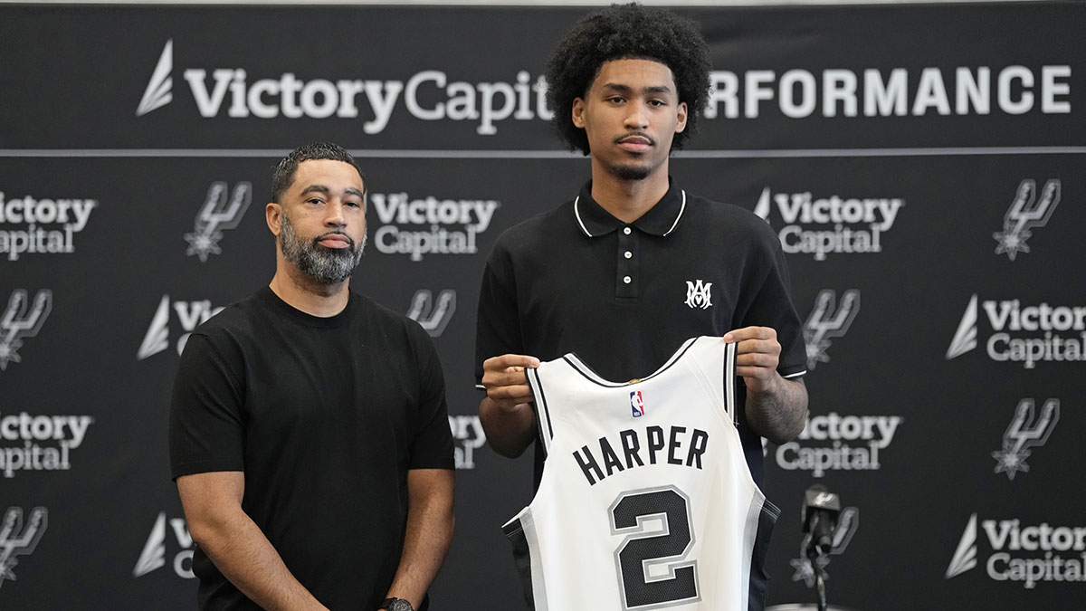 San Antonio first round draft pick Dylan Harper (2) holds up his jersey along with general manager Brian Wright at Victory Capital Performance Center.