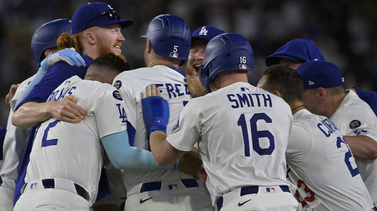 Los Angeles Dodgers players celebrate as they surround first baseman Freddie Freeman (5) after he hit a walk-off single during the ninth inning against the Chicago White Sox at Dodger Stadium.