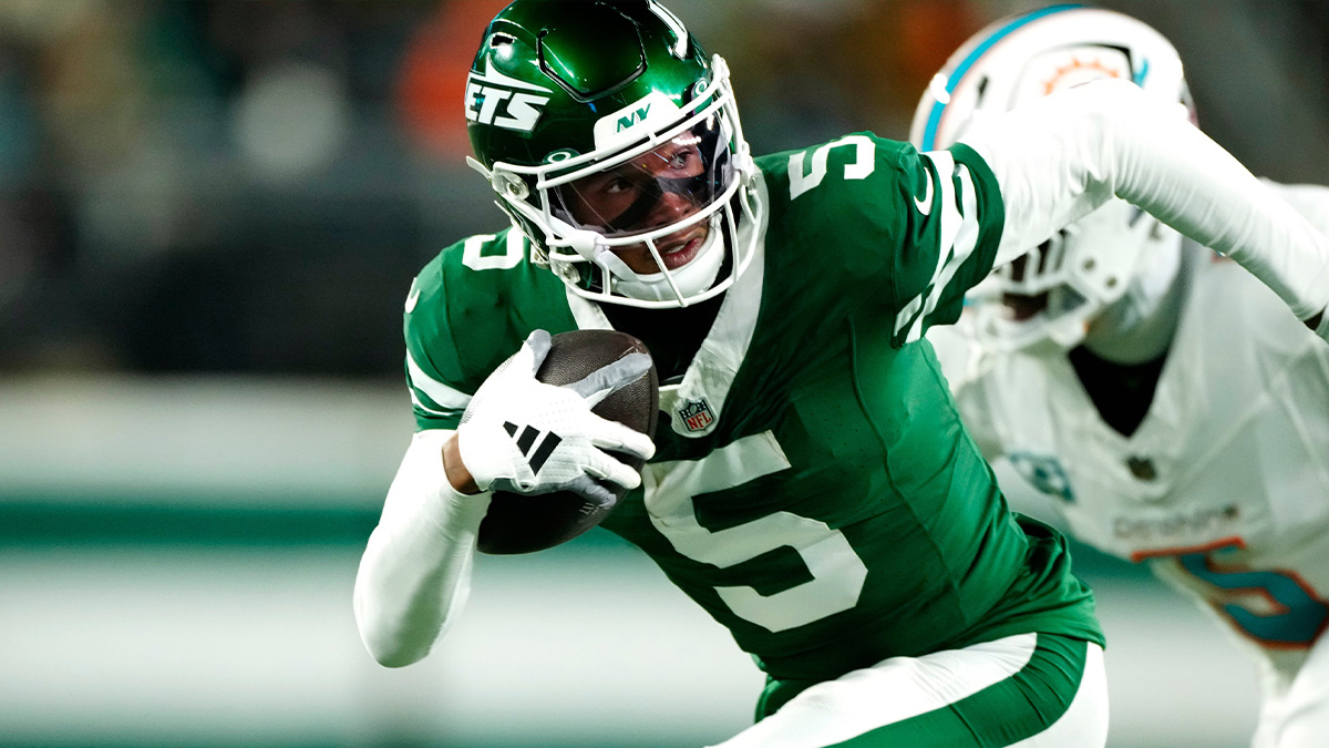 New York Jets wide receiver Garrett Wilson (5) runs with the ball past Miami Dolphins cornerback Jalen Ramsey (5), Sunday January 5, 2025, in East Rutherford.