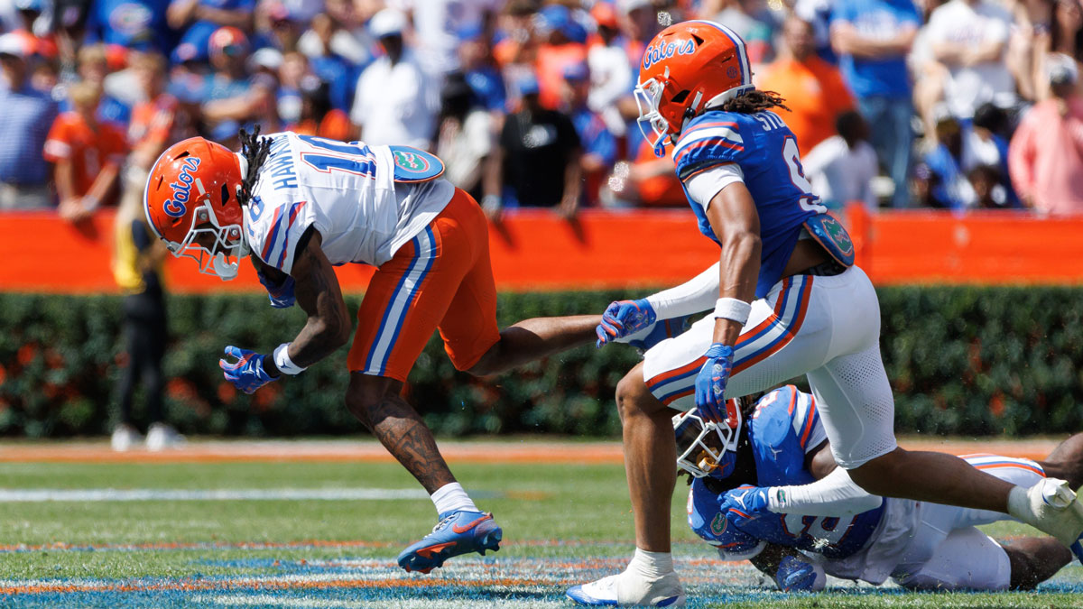Florida Gators wide receiver Tank Hawkins (10) breaks a tackle from Florida Gators wide receiver J. Michael Sturdivant (9) and Florida Gators defensive back Lagonza Hayward (2) during the second half at Ben Hill Griffin Stadium.