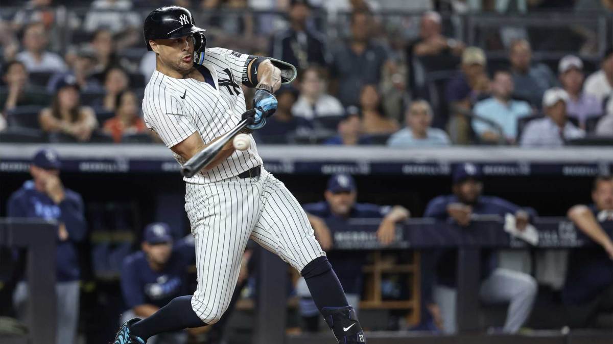 New York Yankees designated hitter Giancarlo Stanton (27) hits an RBI single in the eighth inning against the Tampa Bay Rays at Yankee Stadium.