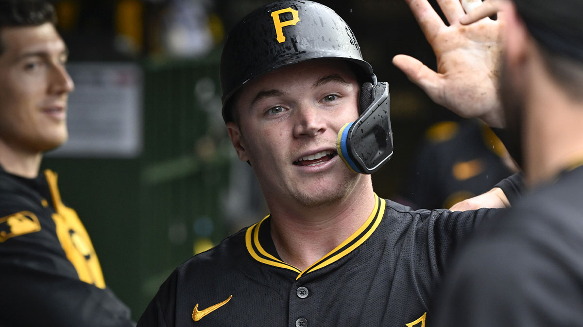 Pittsburgh Pirates catcher Henry Davis (32) high fives teammates in the dugout after scoring against the Chicago Cubs during the eighth inning at Wrigley Field.