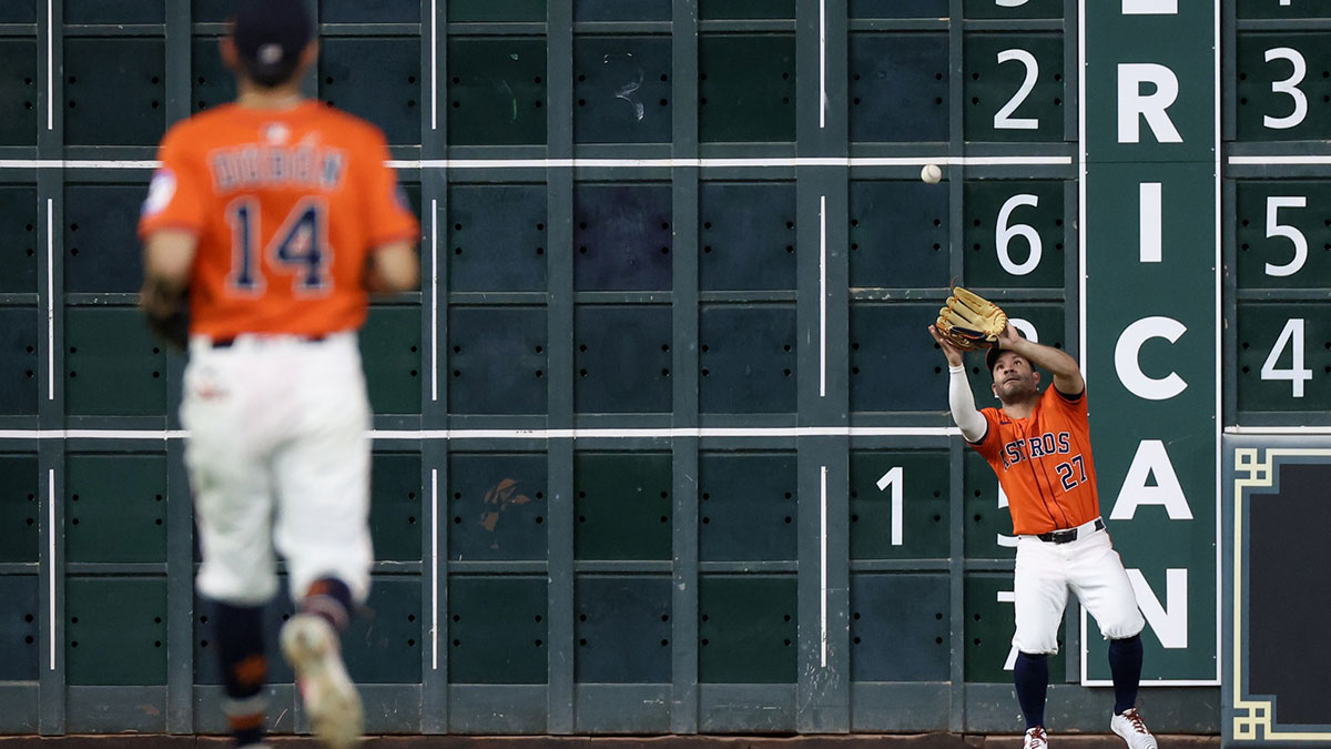 Houston Astros left fielder Jose Altuve (27) catches a Texas Rangers fly ball for an out in the seventh inning at Daikin Park.