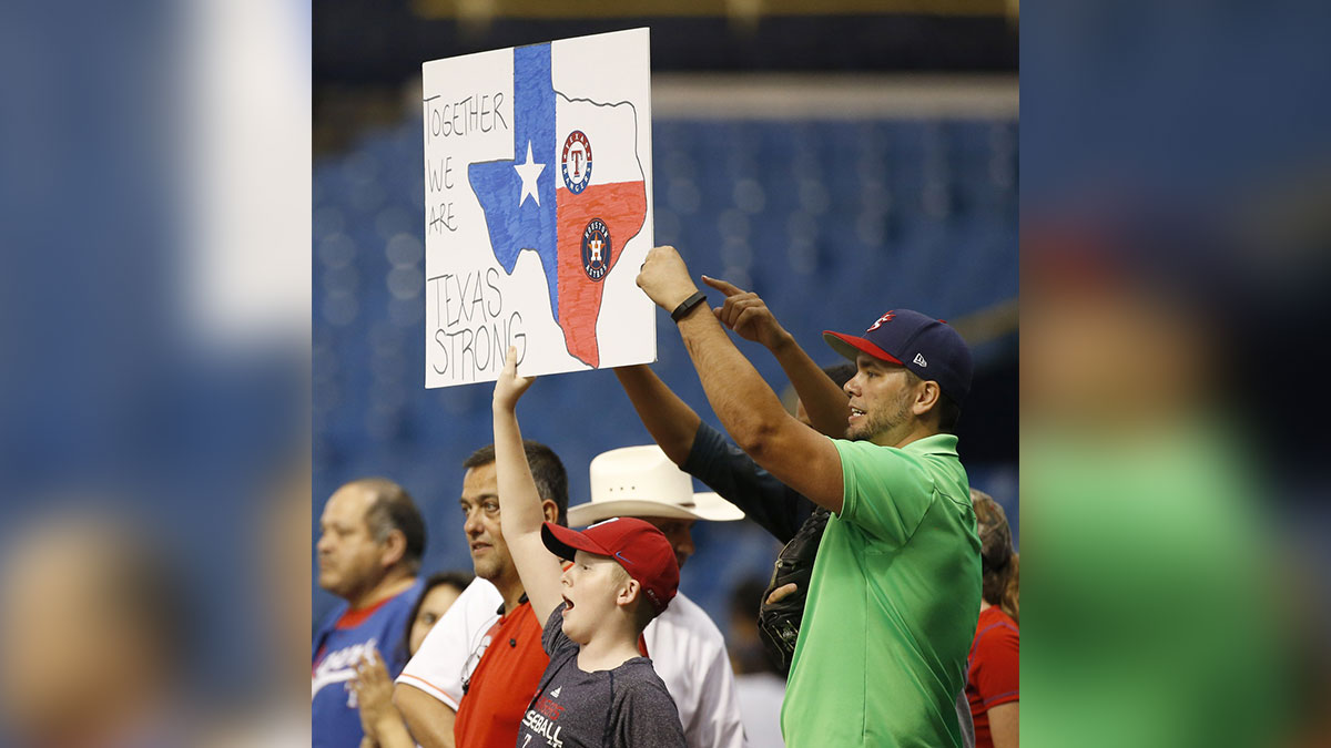 Texas Rangers fans hold a sign saying \"Texas Strong\" for those impacted with Hurricane Harvey in Houston during the eighth inning against the Houston Astros at Tropicana Field.