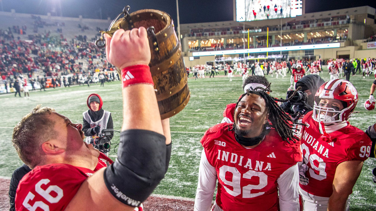 Indiana's Mike Katic (56) hoists the bucket as Marcus Burris Jr (92) and James Carpenter celebrate after the Indiana versus Purdue football game at Memorial Stadium on Saturday, Nov. 30, 2024.