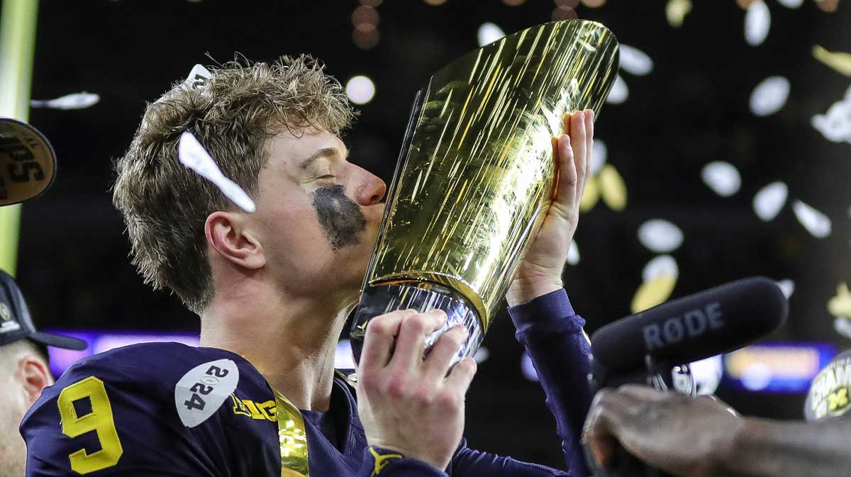 Michigan quarterback J.J. McCarthy (9) misses the trophy to celebrate 34-13 win over Washington at the national championship game at NRG Stadium