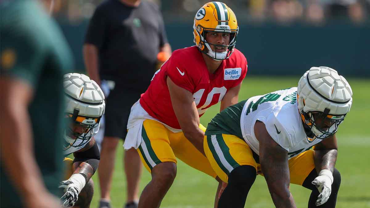Green Bay Packers quarterback Jordan Love (10) takes a snap from offensive lineman Elgton Jenkins (74) during the eighth practice of training camp.