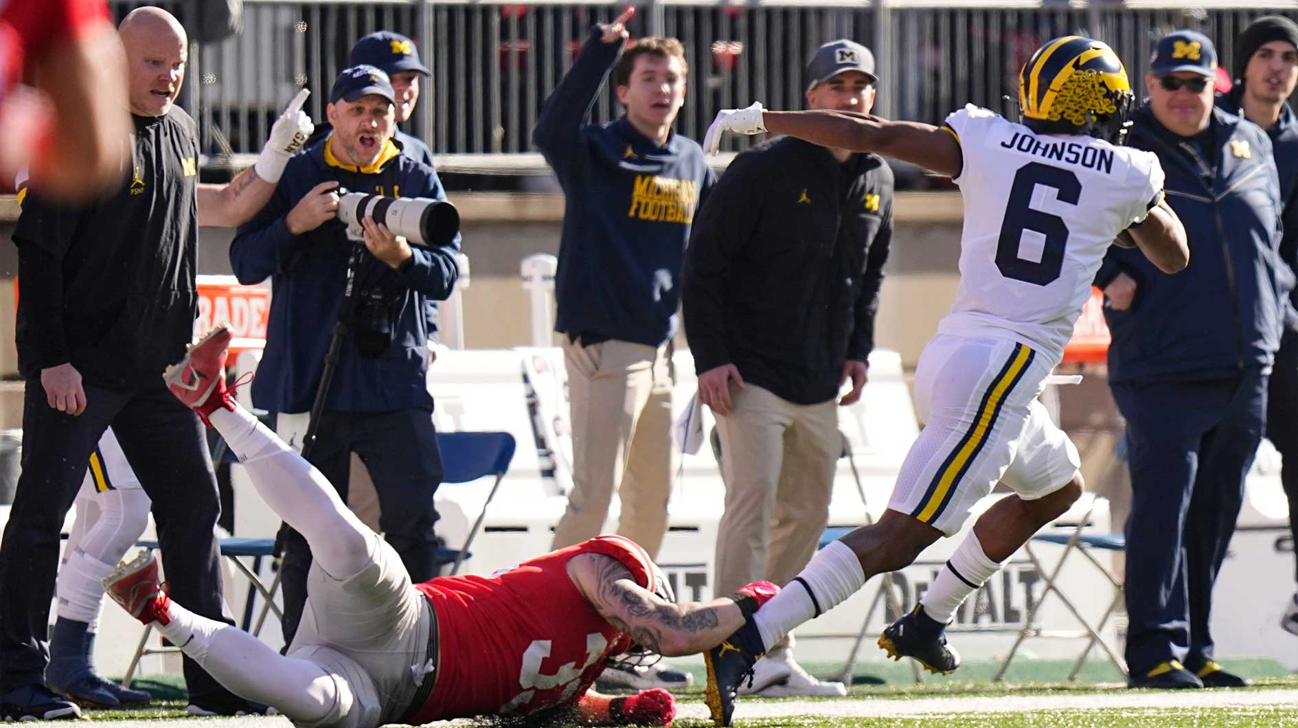 Michigan Wolverines wide receiver Cornelius Johnson (6) escapes tackle by Ohio State Buckeyes defensive end Jack Sawyer (33) on his way to the endzone for a touchdown during the first half of the NCAA football game at Ohio Stadium.