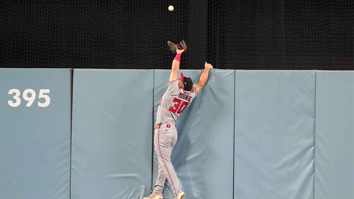Jun 21, 2025; Los Angeles, California, USA; Washington Nationals center fielder Jacob Young (30) attempts to catch a home run ball by Los Angeles Dodgers center fielder Andy Pages (not pictured) in the fifth inning at Dodger Stadium. Mandatory Credit: Kirby Lee-Imagn Images