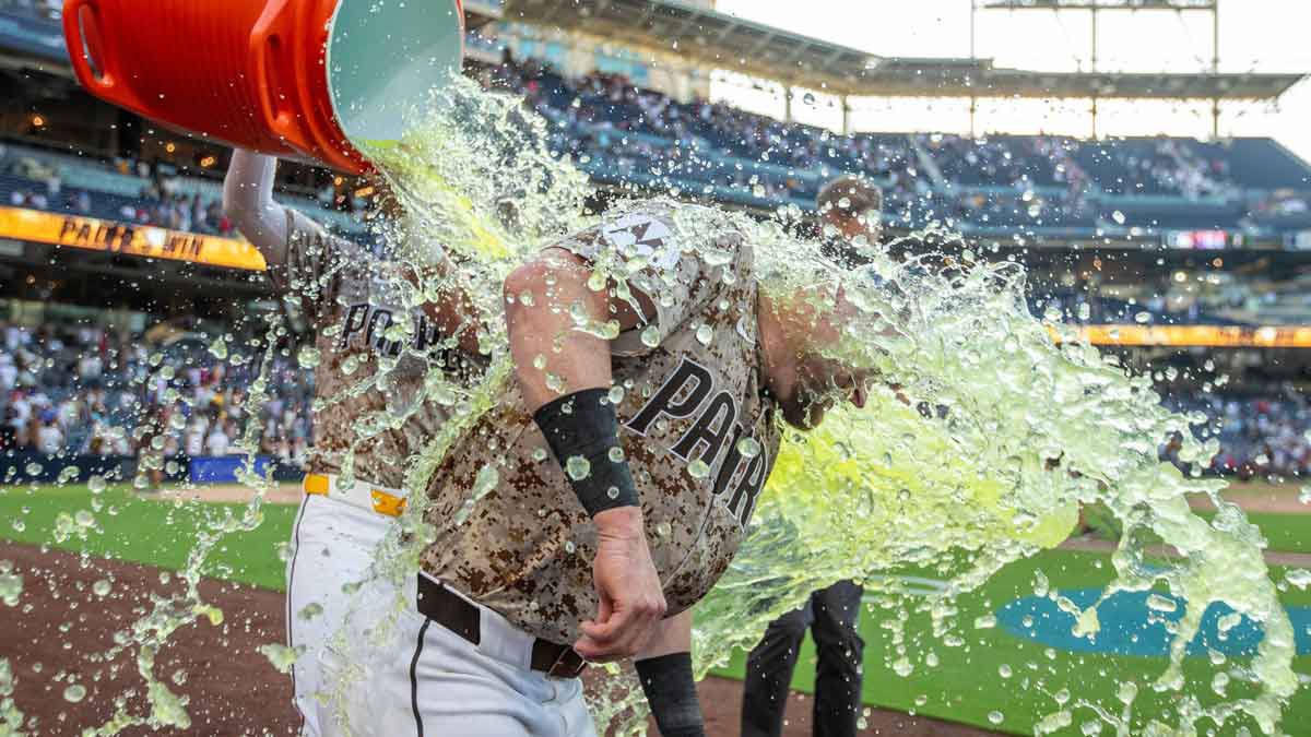 San Diego Padres left fielder Tyler Wade (14) dumps gatorade on San Diego Padres second baseman Jake Cronenworth (9) after the San Diego Padres walkoff the Texas Rangers in the tenth inning at Petco Park.