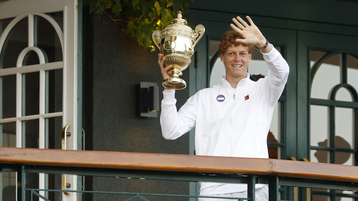 Jannik Sinner (ITA) waves to fans while standing on the South West Hall balcony holding the gentlemen's singles champion trophy, after his match against Carlos Alcaraz (ESP)(not pictured) in the gentlemen's' singles final of The Championships Wimbledon 2025 at All England Lawn Tennis and Croquet Club.