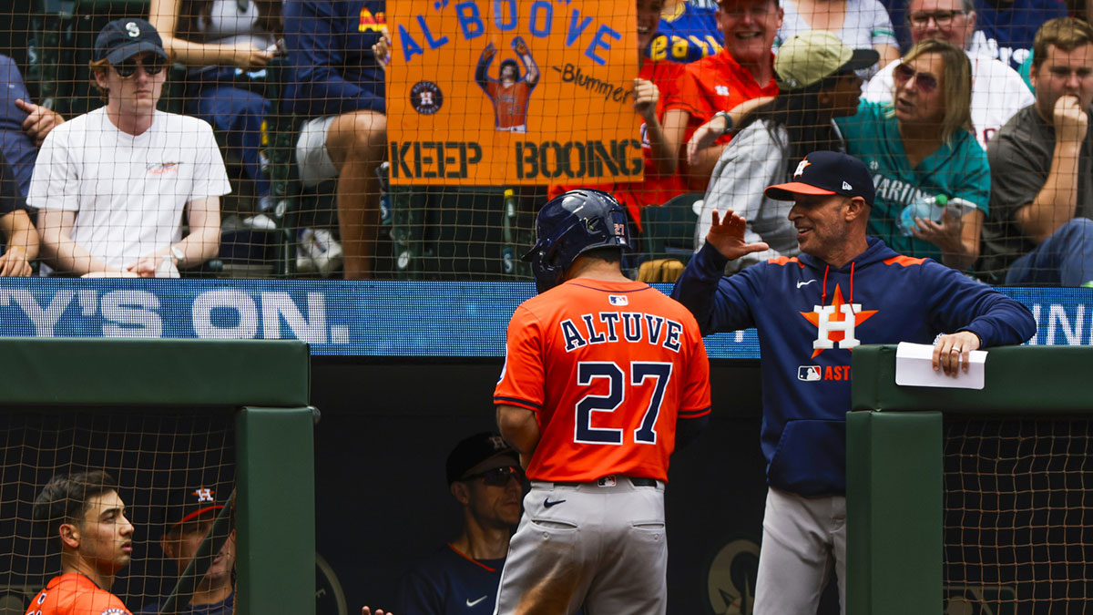 Houston Astros manager Joe Espada (19, right) greets second baseman Jose Altuve (27) in the dugout after a run by Altuve against the Seattle Mariners during the eighth inning at T-Mobile Park.