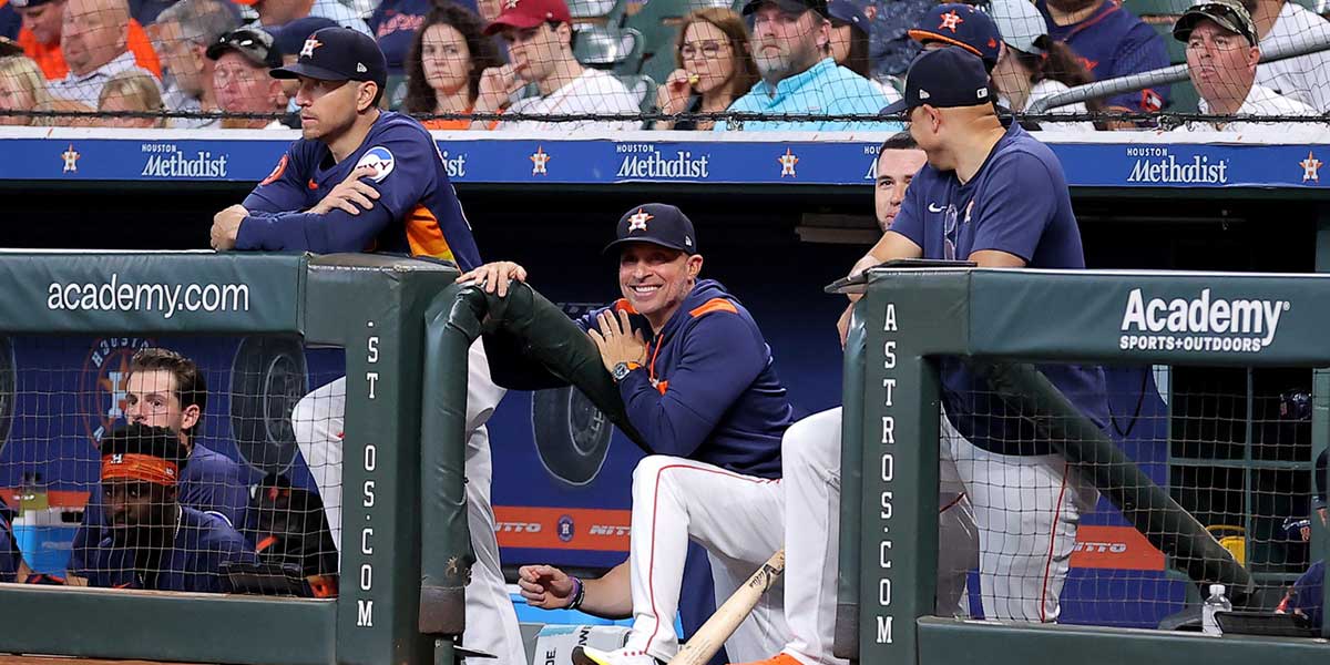 Houston Astros manager Joe Espada (19, center) watches the action from the dugout against the Texas Rangers during the first inning at Daikin Park.