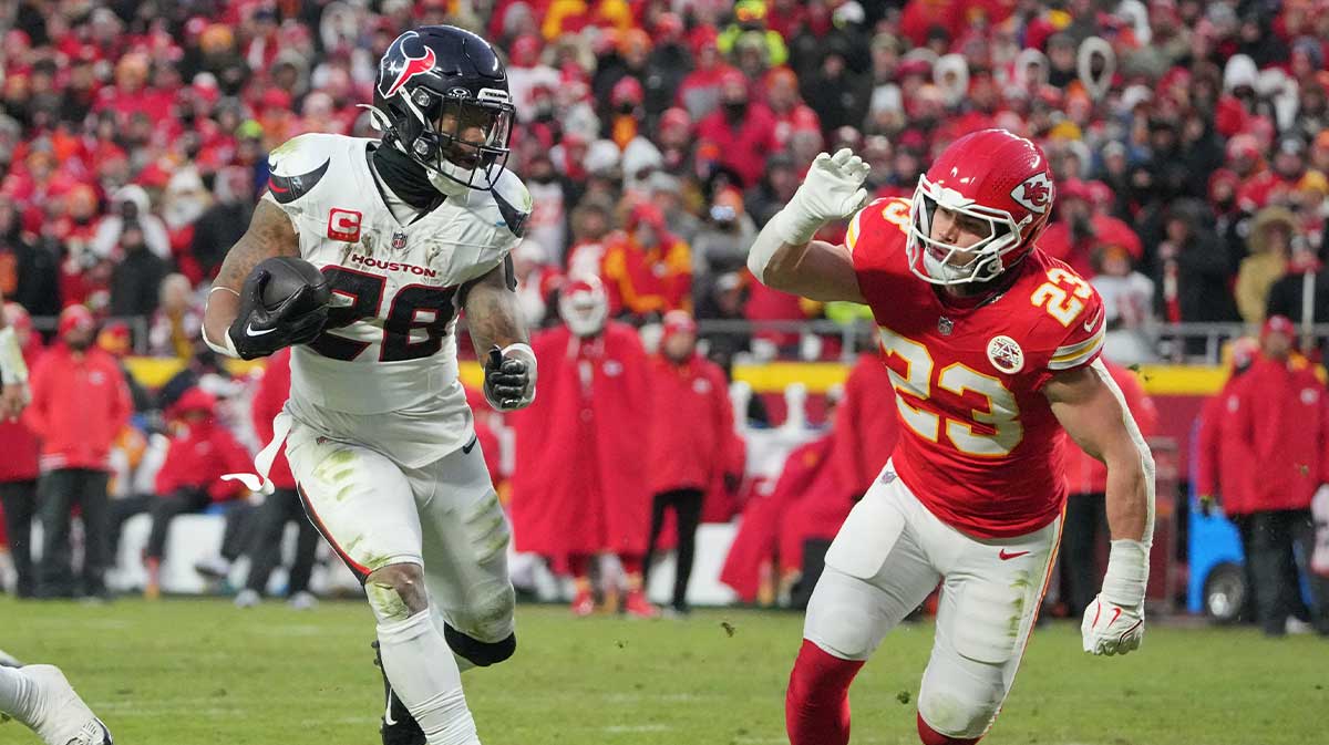 Houston Texans running back Joe Mixon (28) runs the ball as Kansas City Chiefs linebacker Drue Tranquill (23) defends during the second half of a 2025 AFC divisional round game at GEHA Field at Arrowhead Stadium.