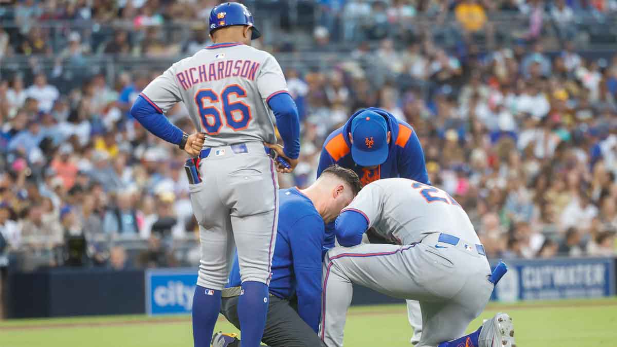 New York Mets right fielder Juan Soto (22) is looked after by the training staff after fouling off a ball off his lower extremity during the fourth inning against the San Diego Padres at Petco Park.