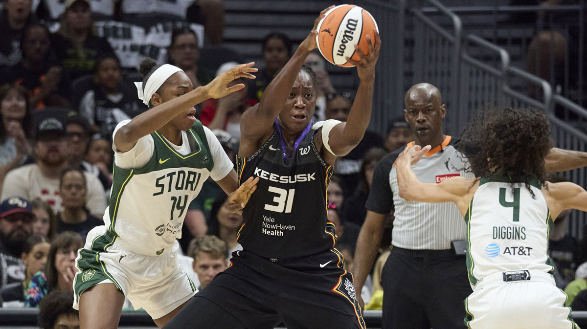 Connecticut Sun center Tina Charles (31) controls the ball against Seattle Storm center Dominique Malonga (14) and Seattle Storm guard Skylar Diggins (4) during the first half at Climate Pledge Arena.