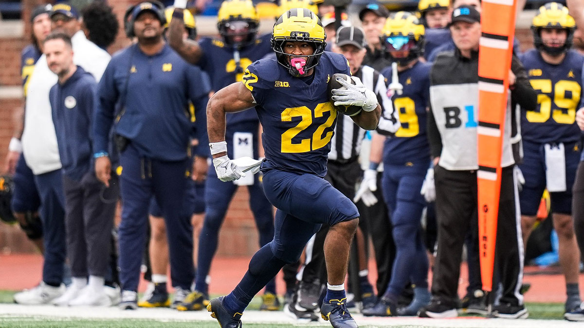 Team Blue running back Justice Haynes (22) runs against Team Maize during the first half of the spring game at Michigan Stadium
