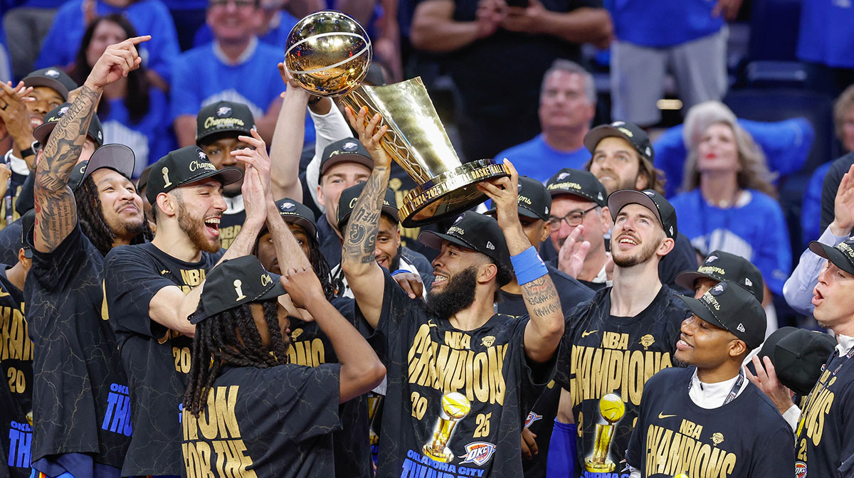 Oklahoma City Thunder forward Kenrich Williams (34) holds up the NBA Finals Larry O'Brien Championship Trophy after his team defeated the Indiana Pacers in game seven of the 2025 NBA Finals at Paycom Center.