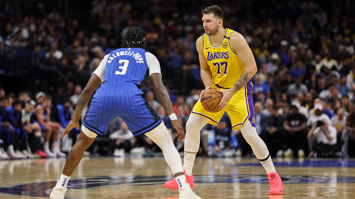 Los Angeles Lakers guard Luka Doncic (77) is guarded by Orlando Magic guard Kentavious Caldwell-Pope (3) in the first quarter at Kia Center.