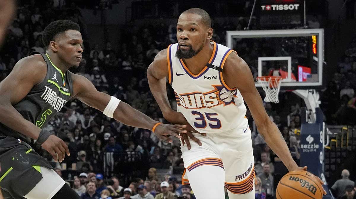 Phoenix Suns forward Kevin Durant (35) brings the ball up as Minnesota Timberwolves guard Anthony Edwards (5) defends him in the fourth quarter at Target Center.