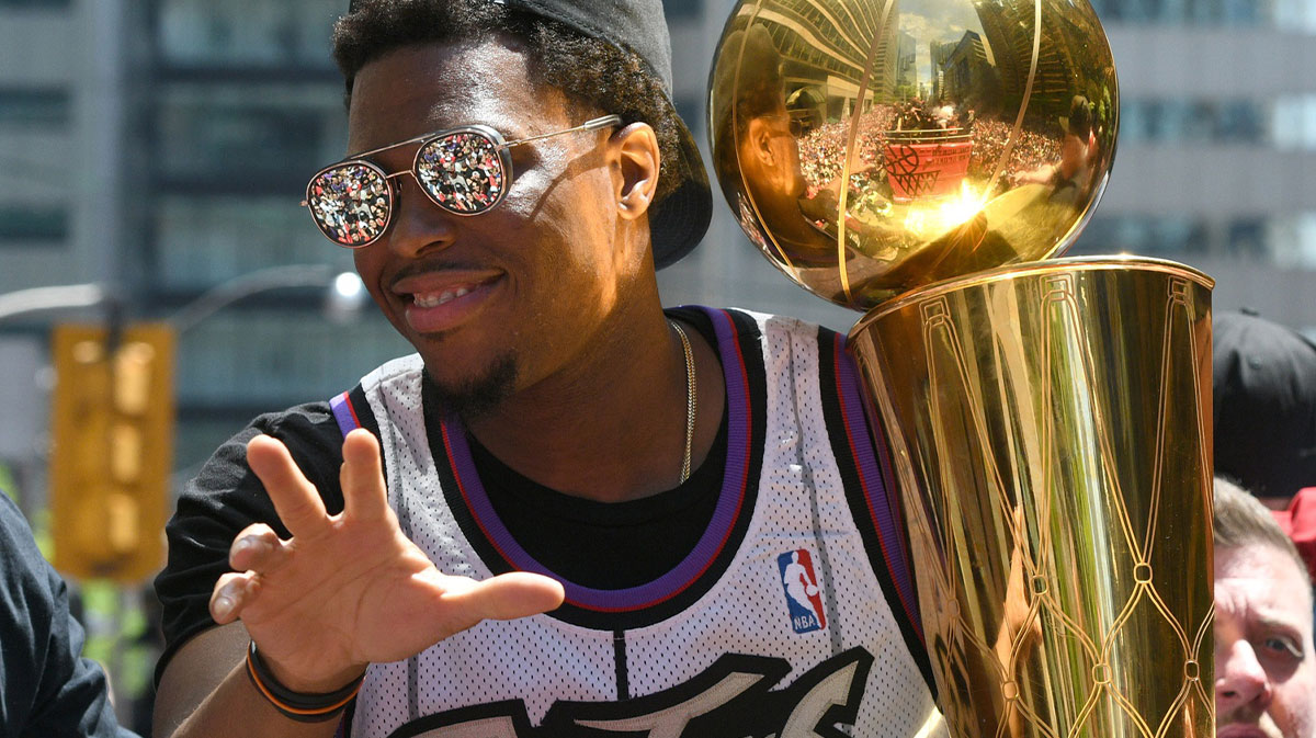 Toronto Raptors guard Kyle Lowry shows off the Larry O'Brien trophy to fans during a parade through downtown Toronto to celebrate their NBA title.
