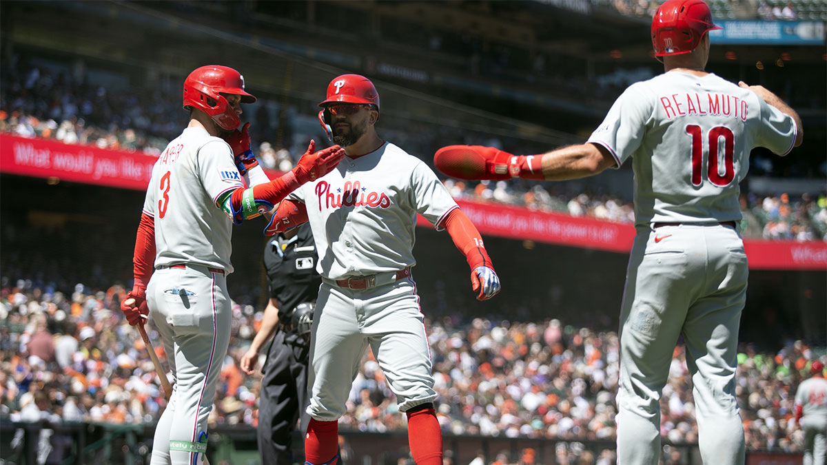 Philadelphia Phillies designated hitter Kyle Schwarber (center) is greeted by teammates Bryce Harper (3) and J.T. Realmuto (10) after hitting a three-run home run against the San Francisco Giants during the eighth inning at Oracle Park.