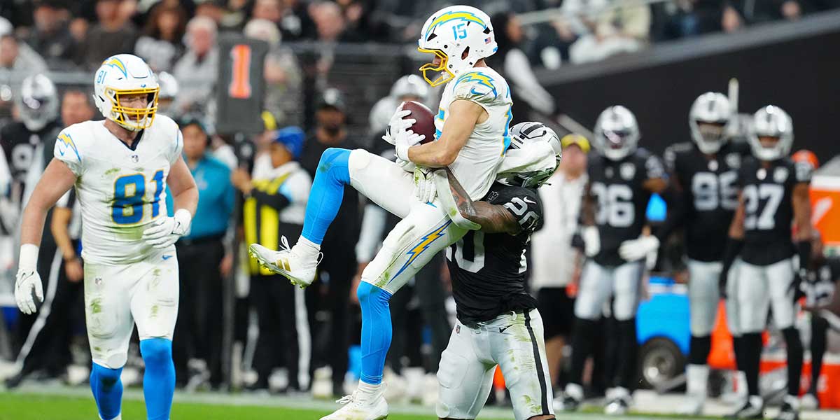 Los Angeles Chargers wide receiver Ladd McConkey (15) makes a catch while being tackled by Las Vegas Raiders safety Isaiah Pola-Mao (20) during the second quarter at Allegiant Stadium.