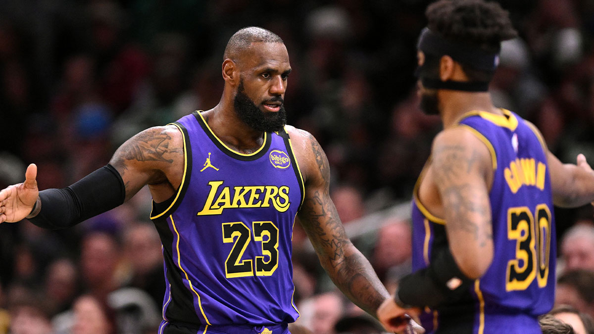 Lakers forward LeBron James (23) high-fives guard Jordan Goodwin (30) during the second quarter of a game against the Boston Celtics at the TD Garden with NBA analyst Zach Lowe in the background