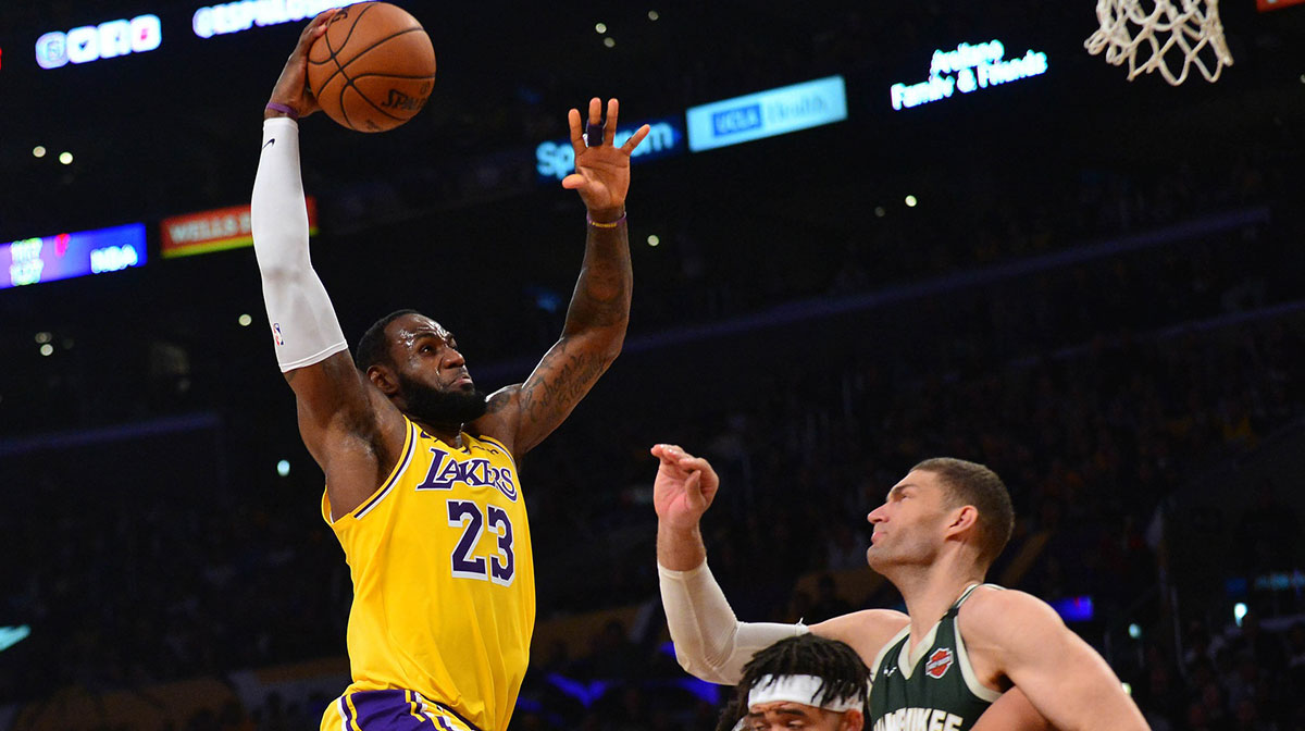 Los Angeles Lakers forward LeBron James (23) moves in for a dunk as center JaVale McGee (7) provides coverage against Milwaukee Bucks center Brook Lopez (11) during the first half at Staples Center.