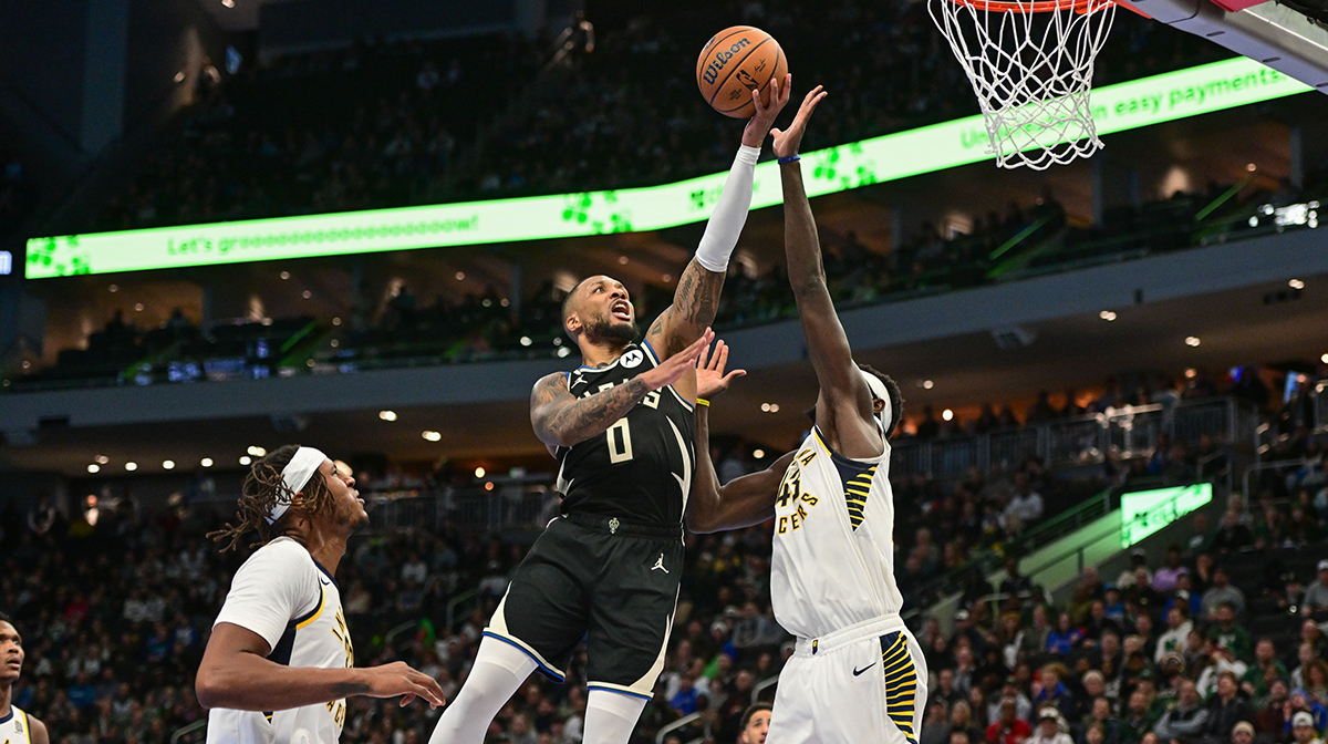 Milwaukee Bucks guard Damian Lillard (0) takes a shot between Indiana Pacers center Myles Turner (33) and forward Pascal Siakam (43) in the fourth quarter at Fiserv Forum.