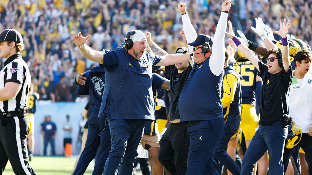 Michigan Wolverines defensive coaches Wink Martindale and Lou Esposito celebrate after a defensive stop against the Alabama Crimson Tide during the second half at Raymond James Stadium.