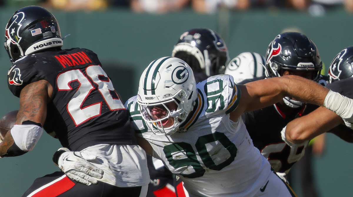 Green Bay Packers defensive end Lukas Van Ness (90) tackles Houston Texans running back Joe Mixon for a loss at Lambeau Field.