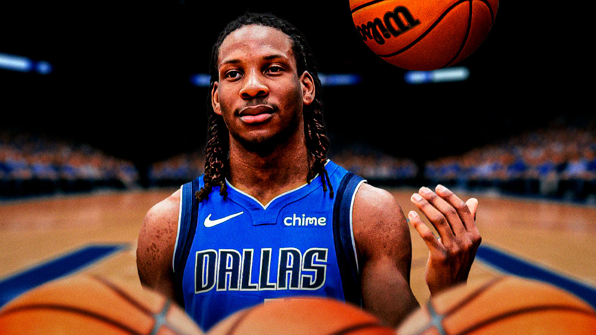 Melvin Ajinca in a Mavericks jersey looking serious.
