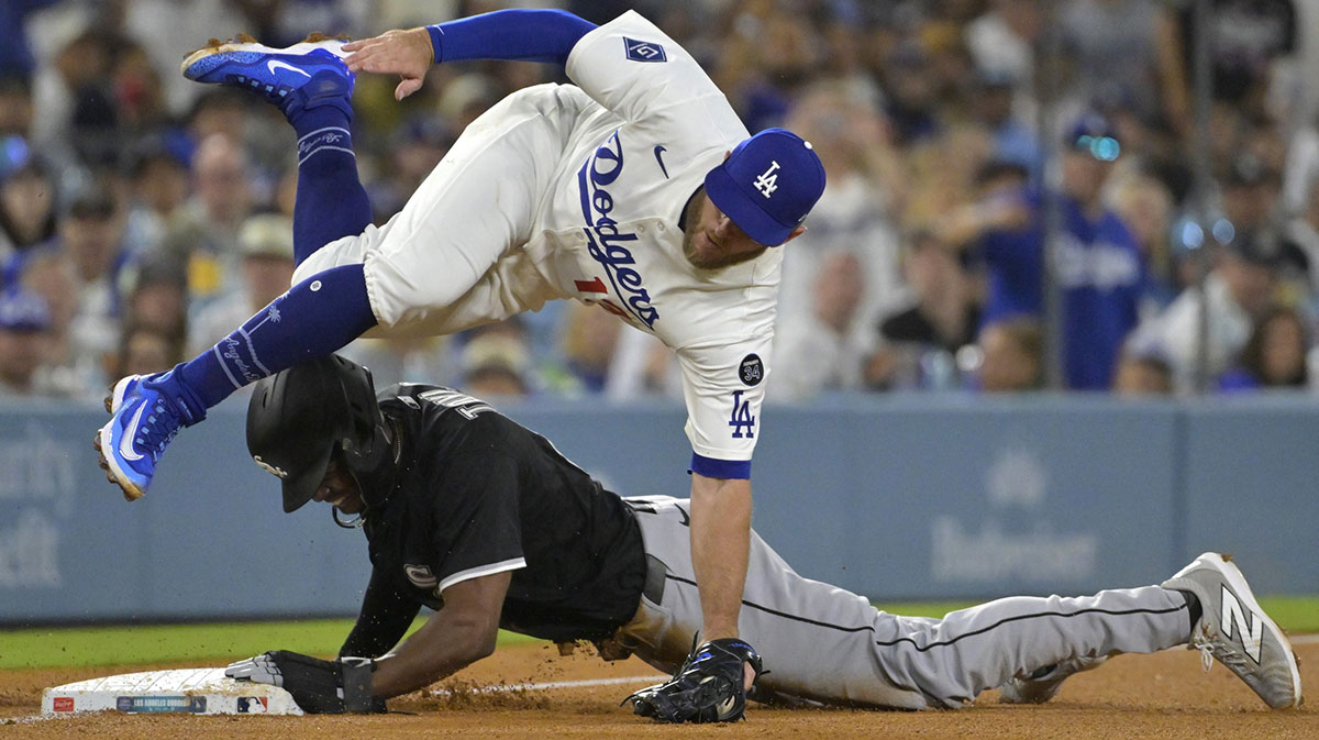 Los Angeles Dodgers third baseman Max Muncy (13) is injured as he flips over Chicago White Sox right fielder Michael A. Taylor (21) after tagging him out on an attempted steal in the fifth inning at Dodger Stadium.
