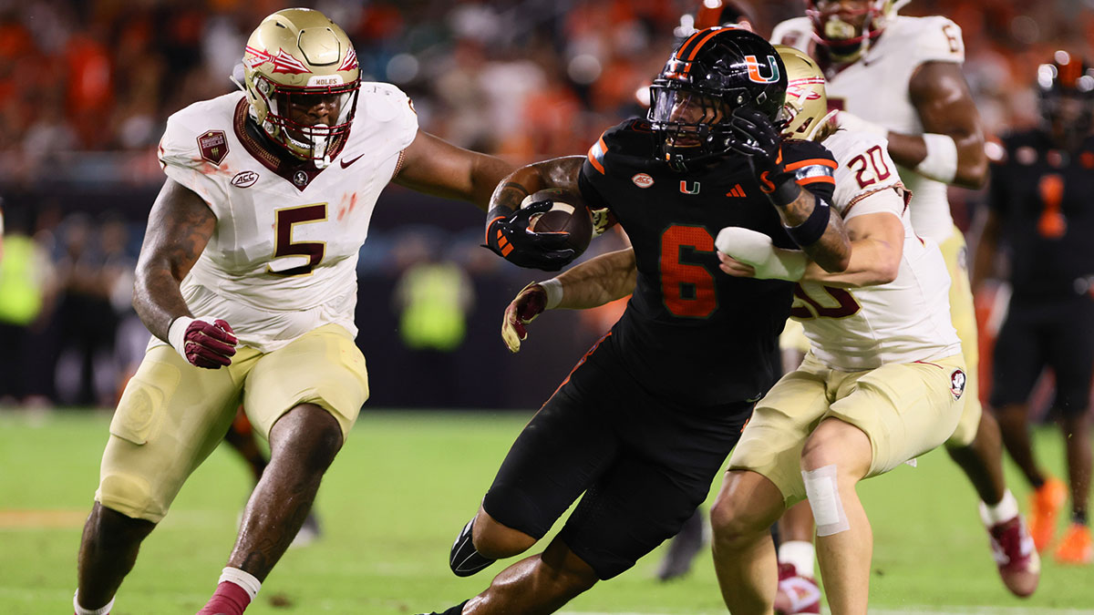 Miami Hurricanes running back Damien Martinez (6) runs with the football past Florida State Seminoles linebacker Blake Nichelson (20) during the second quarter at Hard Rock Stadium.