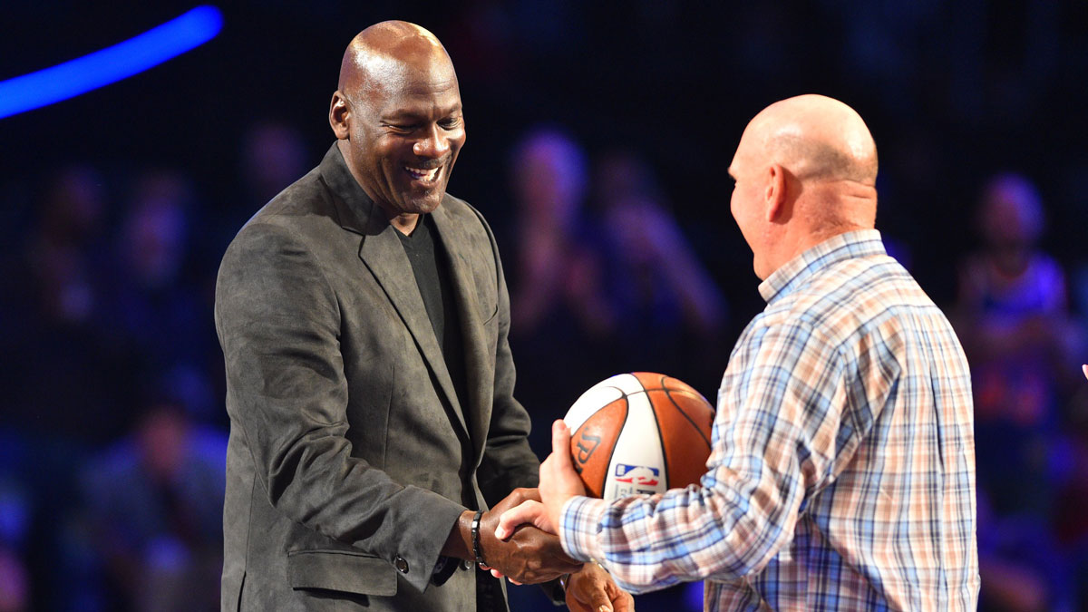 Los Angeles Clippers owner Steve Ballmer greets Charlotte Hornets owner Michael Jordan to pass the game ball to the 2019 host during the 2018 NBA All Star Game at Staples Center.