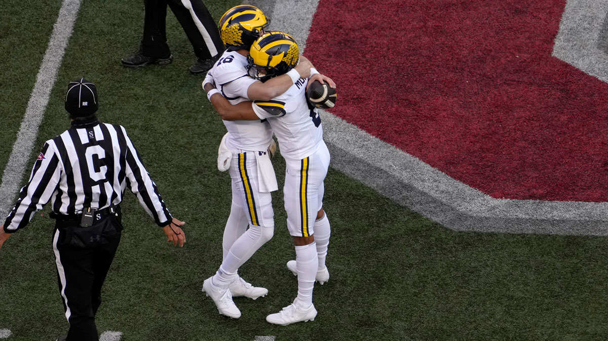 Michigan Wolverines quarterback Davis Warren (16) and Michigan Wolverines wide receiver Tyler Morris (8) embrace following a 13-10 win over the Ohio State Buckeyes in Saturday’s NCAA Division I football game