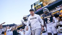 Missouri Tigers head coach Eli Drinkwitz runs out with the team against the Buffalo Bulls prior to a game at Faurot Field at Memorial Stadium.