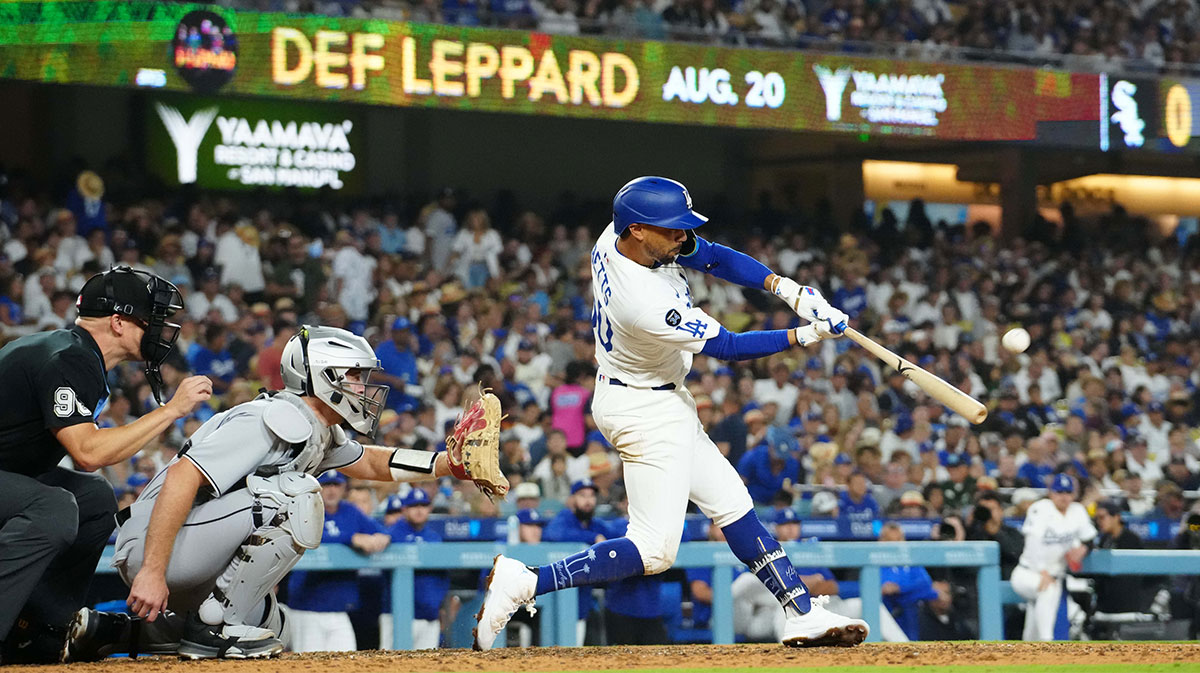 Los Angeles Dodgers shortstop Mookie Betts (50) hits a home run in the seventh inning as Chicago White Sox catcher Kyle Teel (8) and home plate umpire Chris Segal (96) watch at Dodger Stadium.
