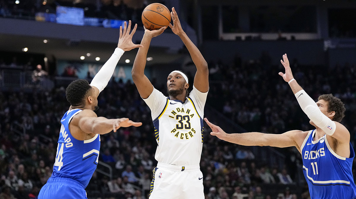 Indiana Pacers center Myles Turner (33) shoot between Milwaukee Bucks forward Giannis Antetokounmpo (34) and center Brook Lopez (11) during the first quarter at Fiserv Forum.