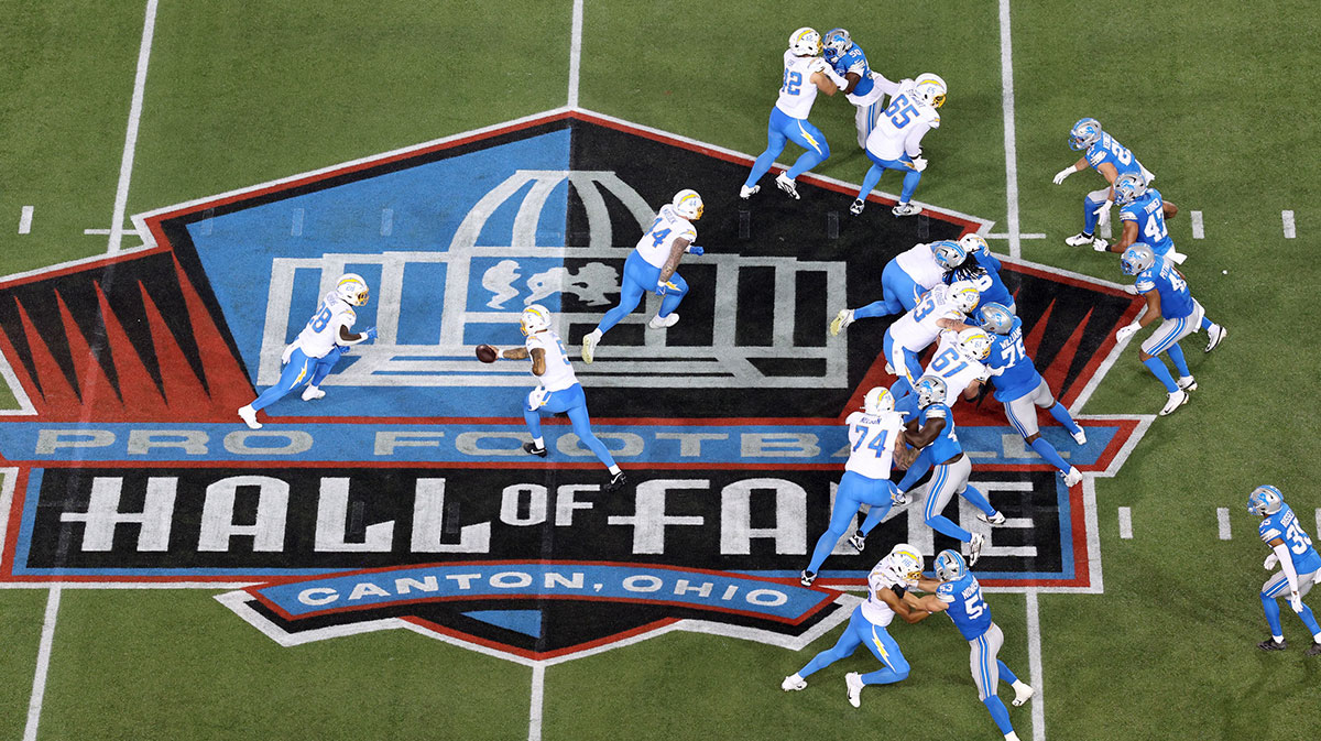 Los Angeles Chargers quarterback Trey Lance (5) hands off to running back Hassan Haskins (28) in the third quarter against the Detroit Lions at Tom Benson Hall of Fame Stadium.