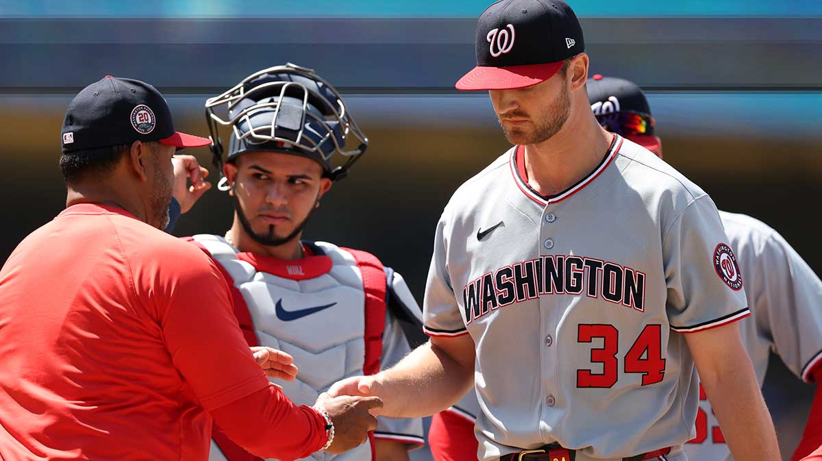 Washington Nationals starting pitcher Michael Soroka (34) hands a ball to manager Dave Martinez (4, left) as he is taking out from the game during the sixth inning at Dodger Stadium.