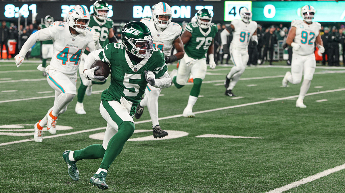 New York Jets wide receiver Garrett Wilson (5) gains yards after catch as Miami Dolphins linebacker Chop Robinson (44) pursues during the first half at MetLife Stadium.