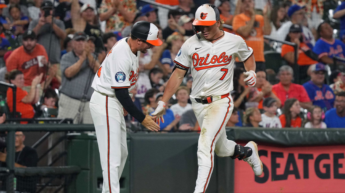 Baltimore Orioles second baseman Jackson Holliday (7) greeted by third base coach Buck Britton (46) following his solo home run during the seventh inning against the New York Mets at Oriole Park at Camden Yards.