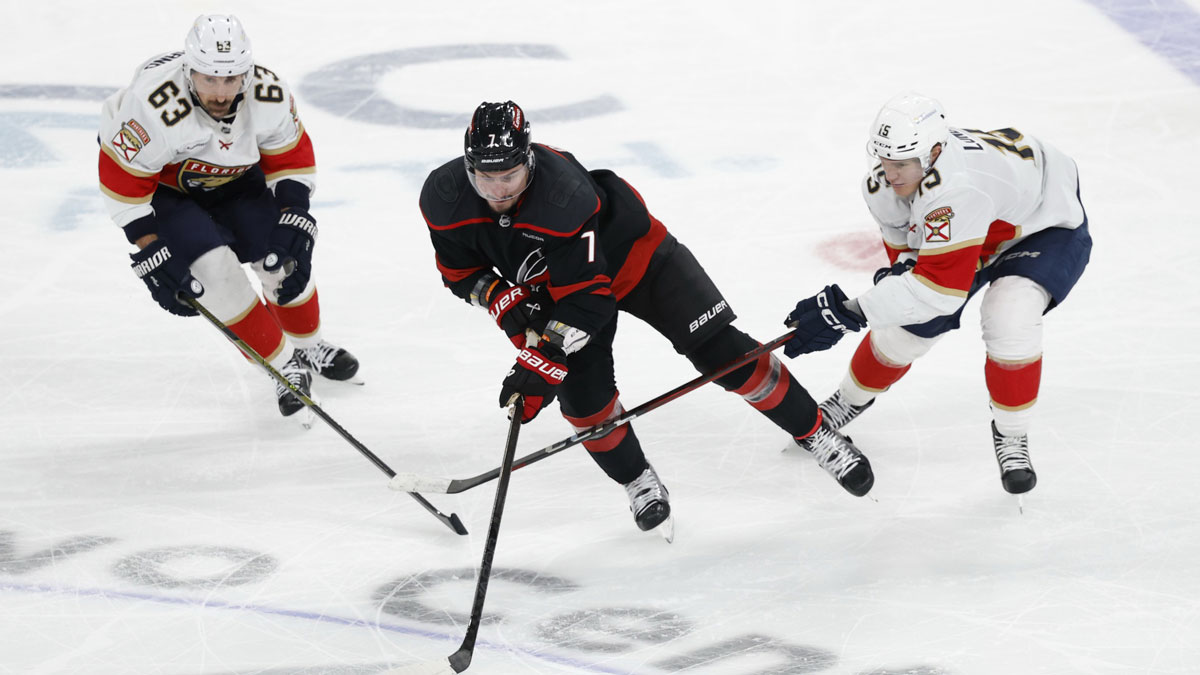 Carolina Hurricanes defenseman Dmitry Orlov (7) skates with the puck as Florida Panthers center Brad Marchand (63) and Panthers center Anton Lundell (15) defend in game five of the Eastern Conference Final of the 2025 Stanley Cup Playoffs at Lenovo Center.