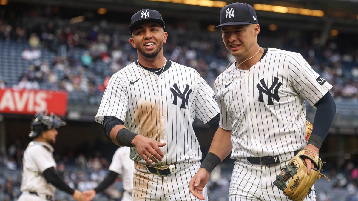 New York Yankees third baseman Oswald Peraza (18) and shortstop Anthony Volpe (11) jog off the field after the top of the eighth inning against the Texas Rangers at Yankee Stadium.