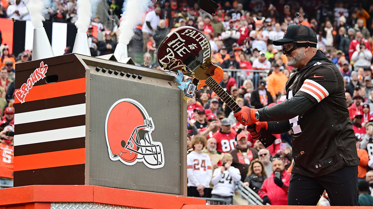 Former Cleveland Browns kicker Phil Dawson smashes a guitar with San Francisco 49ers logos before the game between the Browns and the 49ers at Cleveland Browns Stadium.